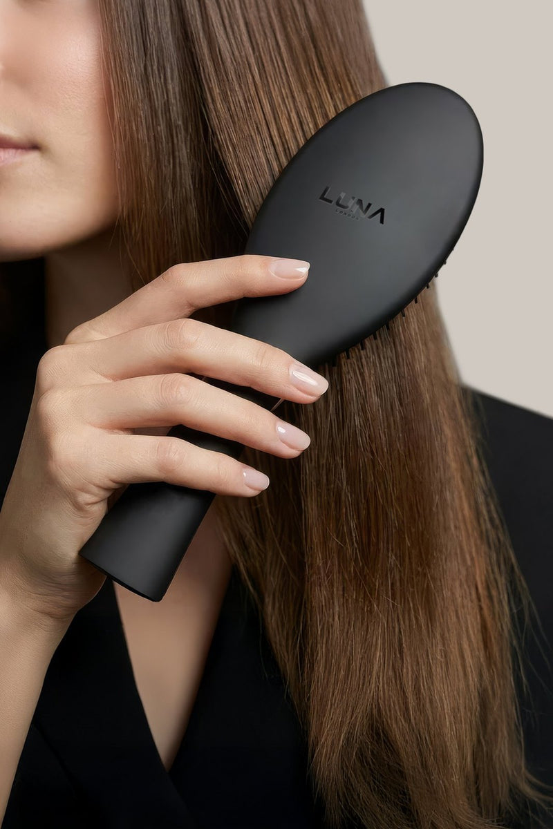 Woman brushing long hair with the DETANGLER detangling hair brush